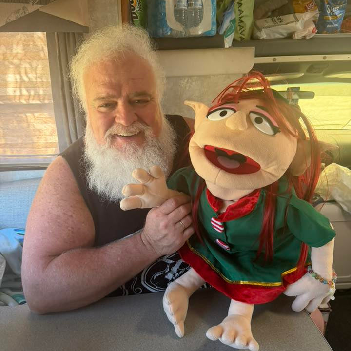 Man with a beard holding a puppet in a casual setting